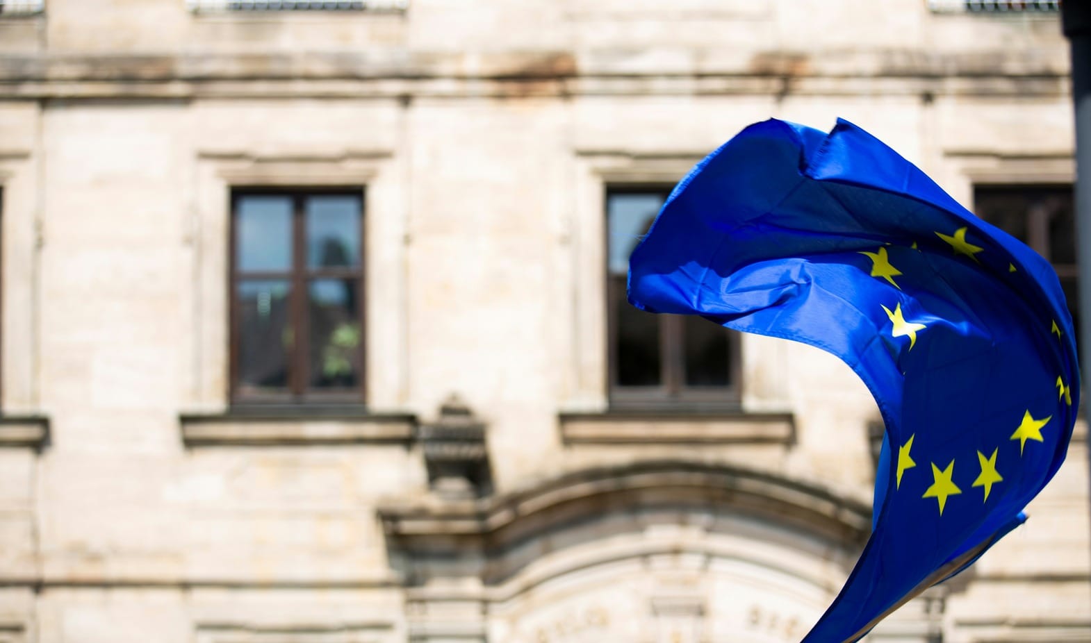 Η σημαία της Ευρωπαϊκής Ένωσης κυματίζει μπροαστά από κτίριο