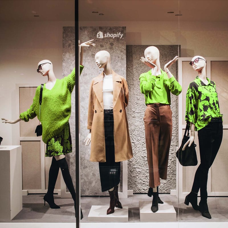 Shopify eshop display with doll mannequins in green and black clothes posing