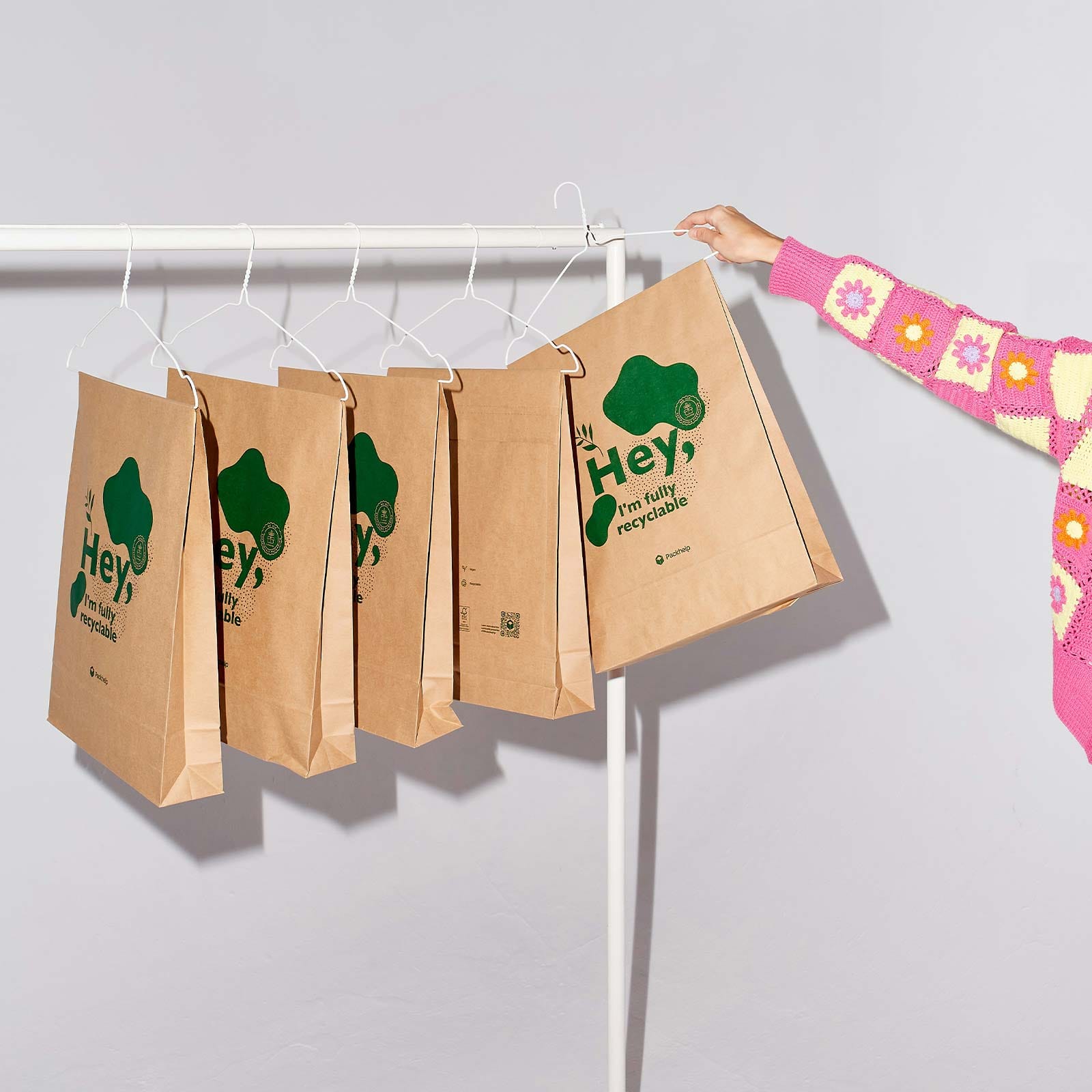 Sustainability sto eCommerce five paper bags hanged with a girl's hand in 
