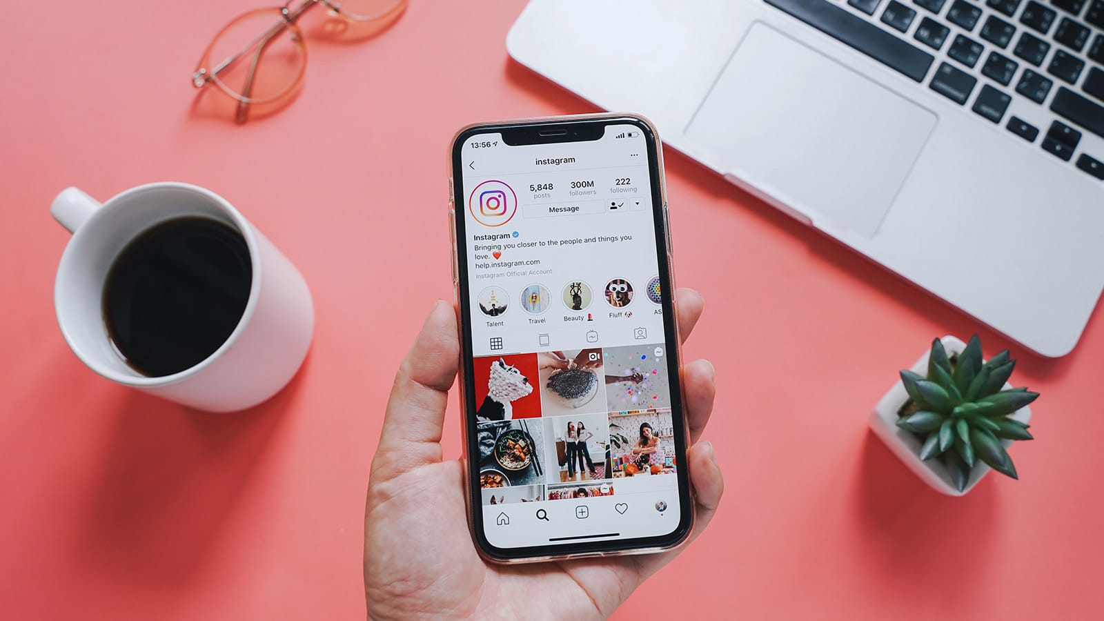 Ανοιχτό Instagram σε κινητό πάνω από λάπτοπ και κούπα καφέ