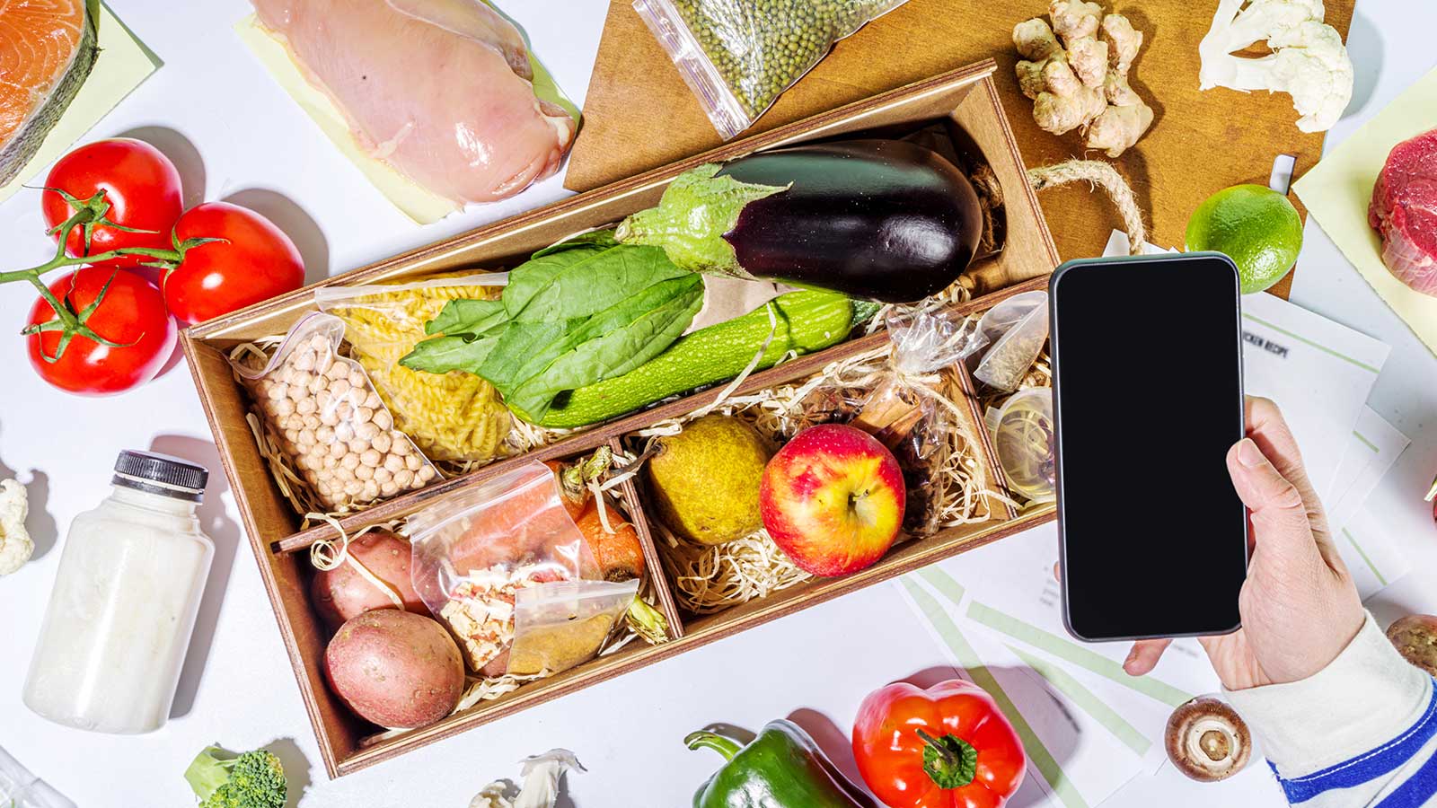 Shopify Subscription Boxes με υλικά μαγειρικής και κινητό να τα φωτογραφίζει