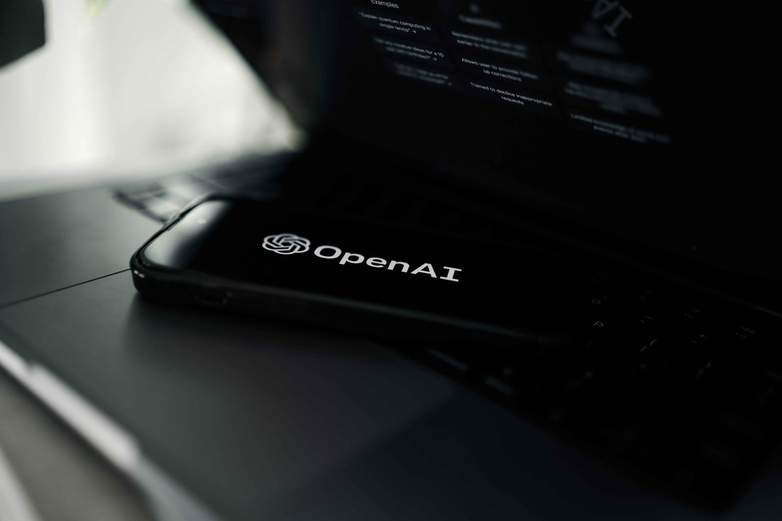 Κινητό πάνω σε λάπτοπ με το λογότυπο της OpenAI