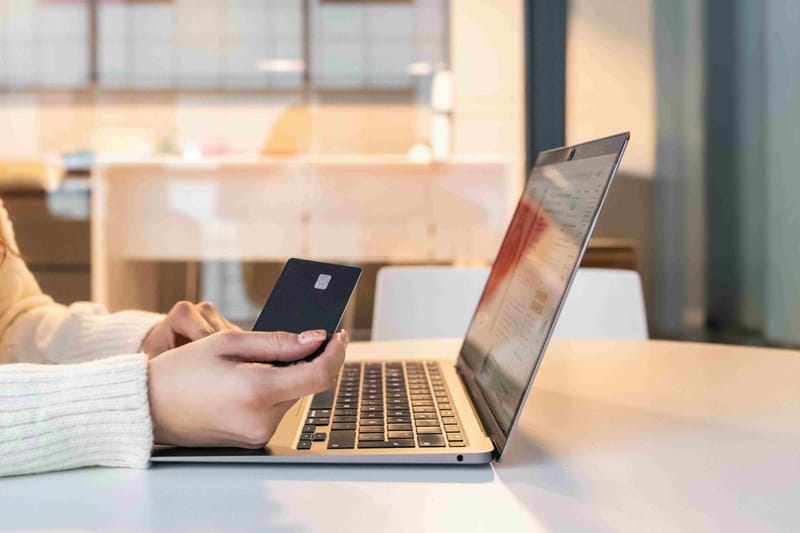 Χέρι με κάρτα που πληρώνει με Buy Now Pay Later σε λάπτοπ